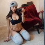 Ana Cheri hot fitness model taking a selfie in stockings and a sports bra.